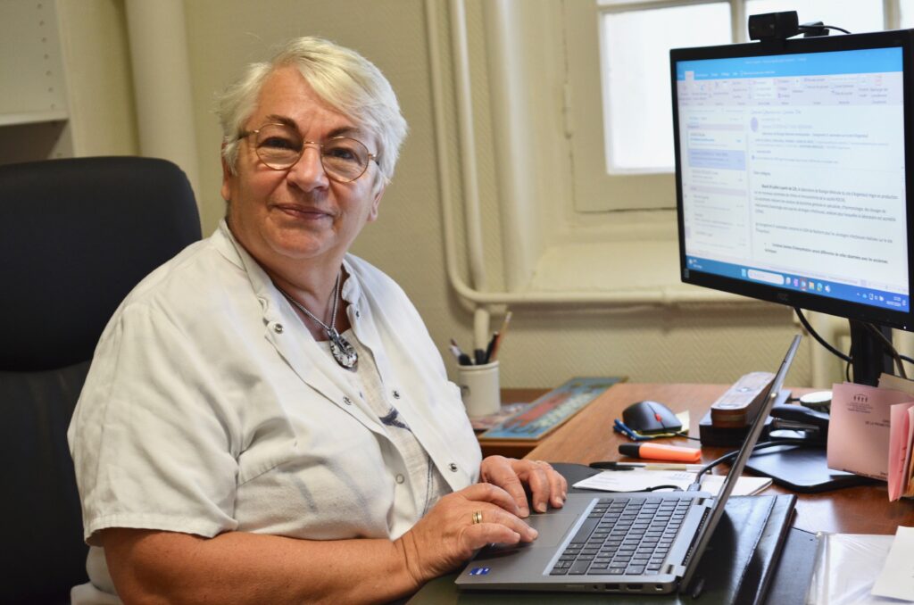 Photo portrait de Florence devant son ordinateur à l'hôpital de Nanterre